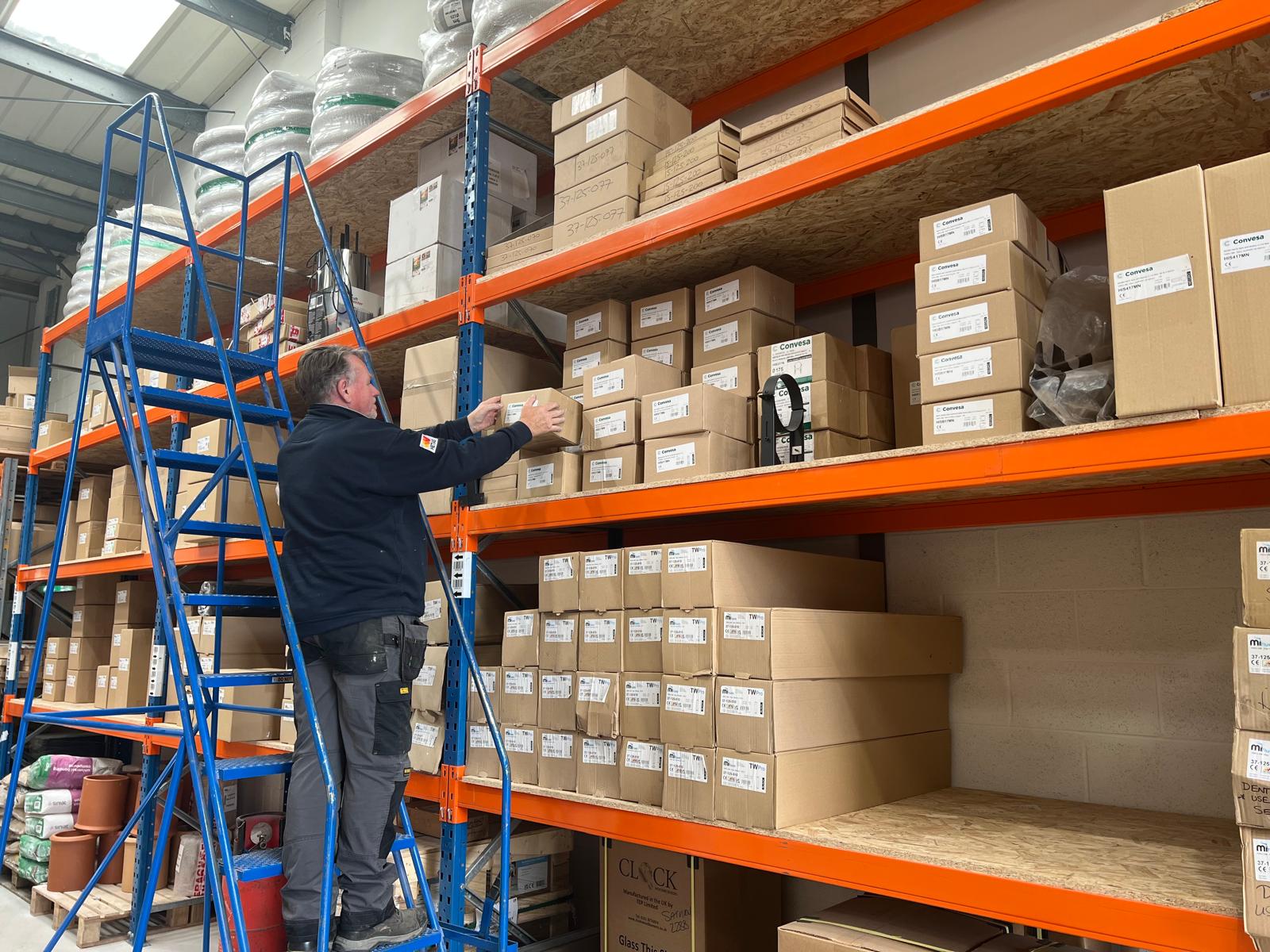 Warehouse shelves with boxed flue components being picked for dispatch